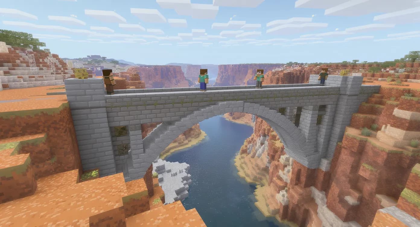 Deux joueurs Minecraft construisent ensemble un pont en pierre lisse au-dessus d’un canyon, sans équipement enchanté ni items custom, illustrant la coopération typique d’un serveur vanilla pur.